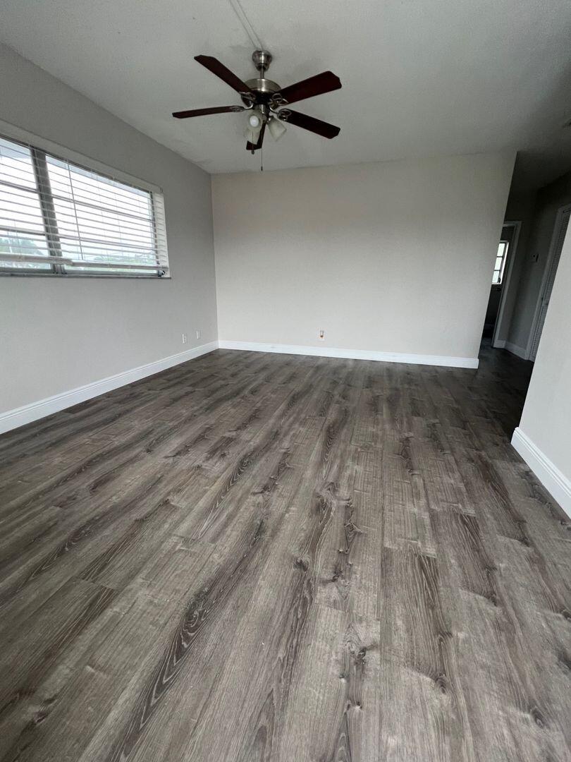 480 West Camino Real, Unit 31 Boca Raton, FL 33432 - Photo 4 of 22 an empty room with wooden floor and windows