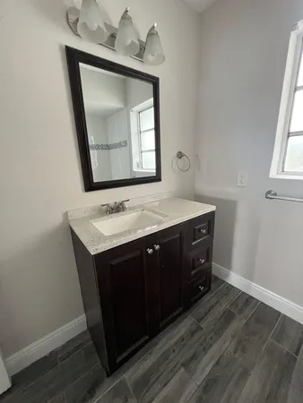 a bathroom with a sink vanity and mirror