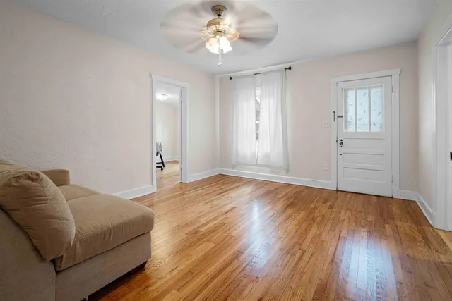 a living room with furniture and a ceiling fan