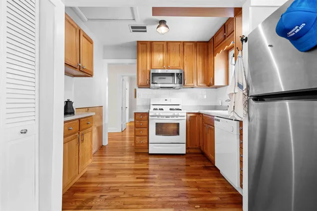 a kitchen with stainless steel appliances a refrigerator sink and microwave