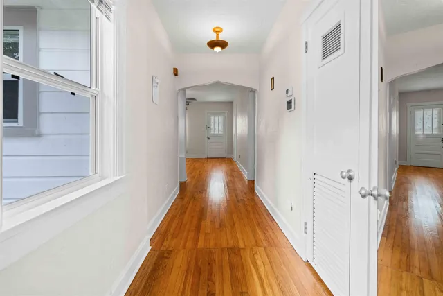 a view of a hallway with wooden floor and a staircase