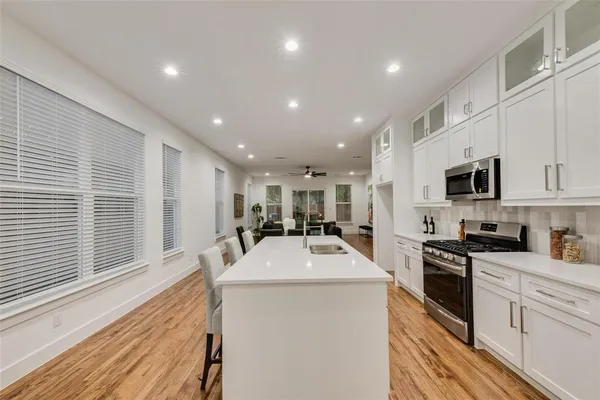 a kitchen with stainless steel appliances a microwave sink stove refrigerator and cabinets