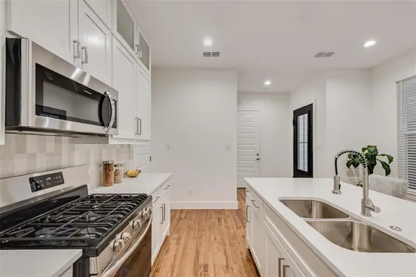 a kitchen that has a sink and a stove top oven