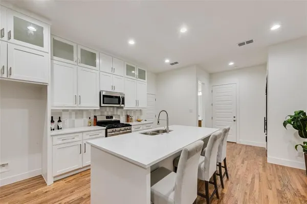 a kitchen with a sink a microwave a stove and cabinets