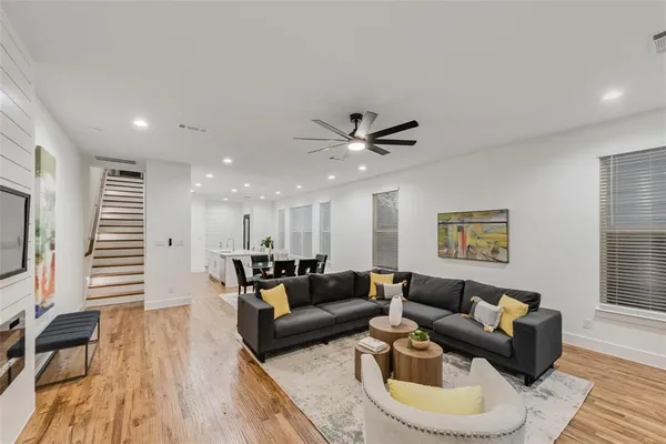 a living room with furniture and a wooden floor