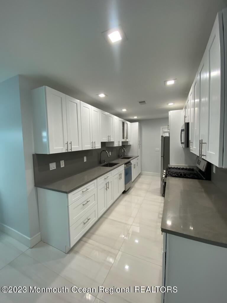 258 Norgrove Avenue Long Branch, NJ 07740 - Photo 6 of 16 a kitchen with stainless steel appliances granite countertop a sink and a stove