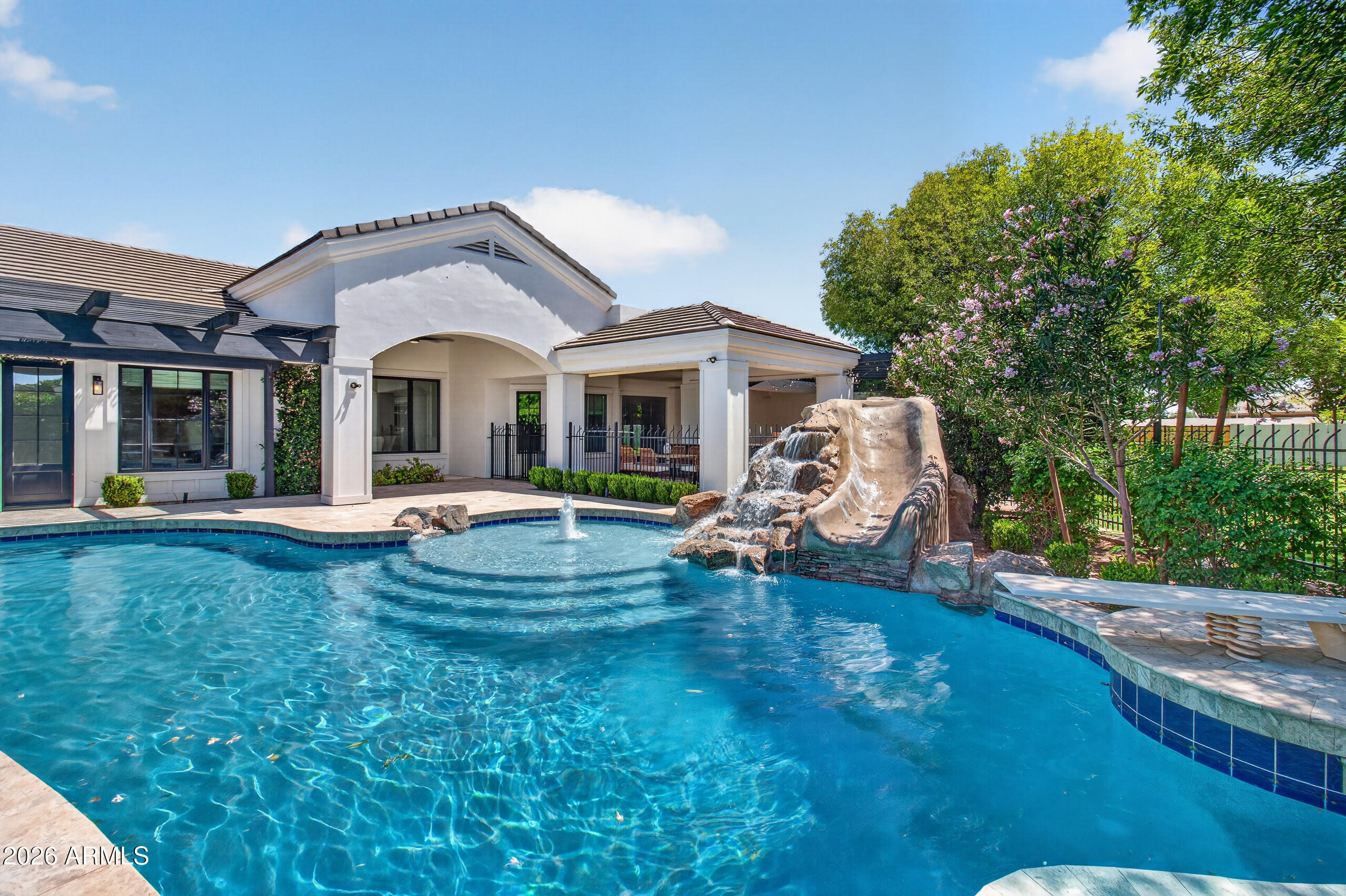 2677 East Queen Creek Road Gilbert, AZ 85297 - Photo 117 of 128 a view of a white house with a big yard and large trees