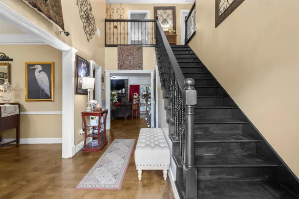 a view of staircase with lots of frames on wall and windows