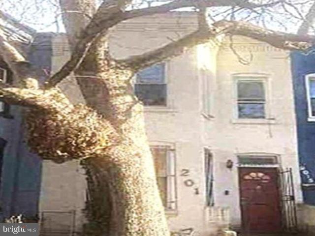 a front view of a house with a tree