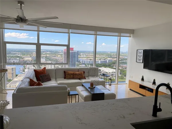 a living room with furniture and large windows