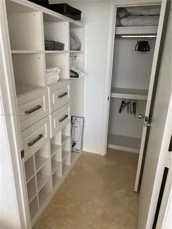 a view of walk in closet with empty racks