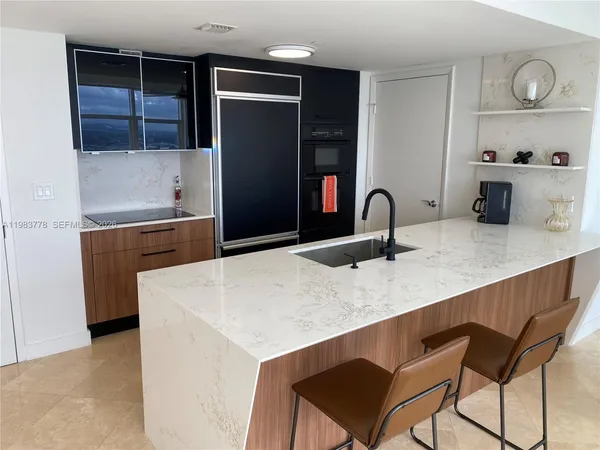 a kitchen with granite countertop a refrigerator and a sink