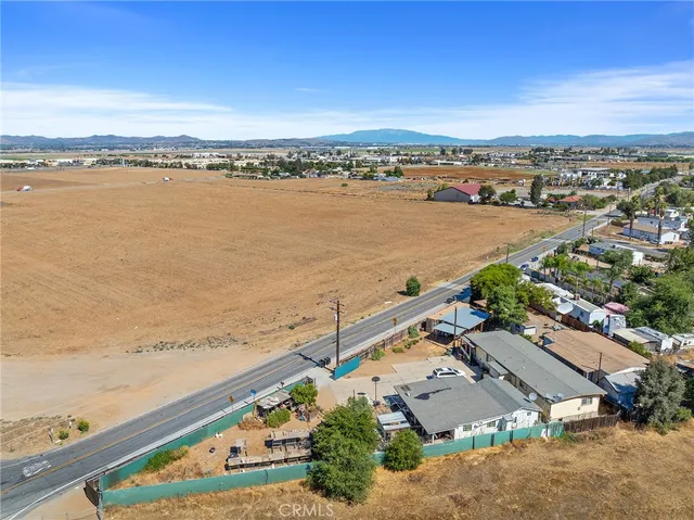 an aerial view of ocean and residential houses with outdoor space