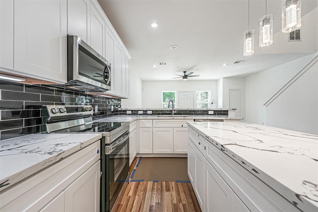 5317 Chennault Road, Unit A Houston, TX 77033 - Photo 3 of 11 a kitchen with stainless steel appliances granite countertop a stove and a sink