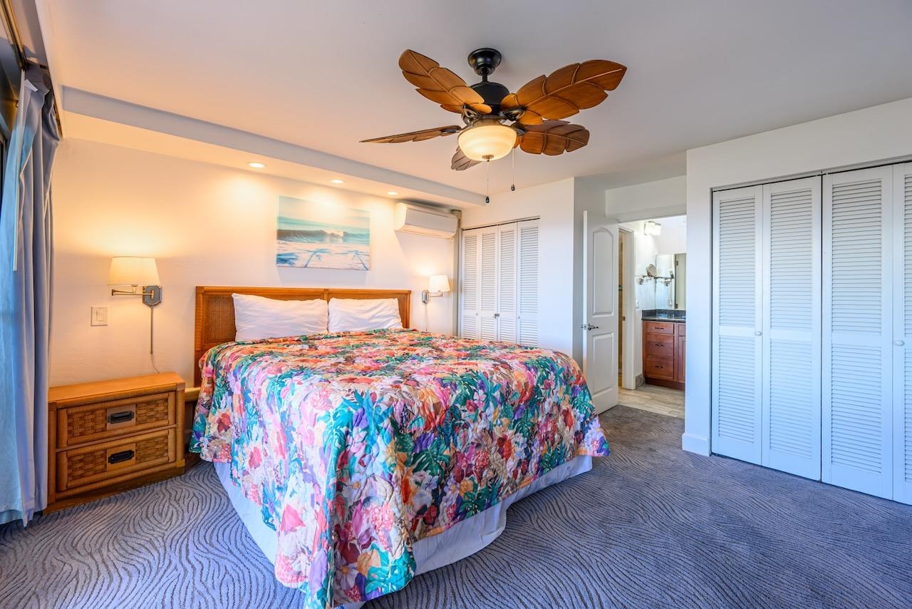 4909 Lower Honoapiilani Road, Unit D6 Lahaina, HI 96761 - Photo 24 of 47 a bedroom with a large bed and a chandelier