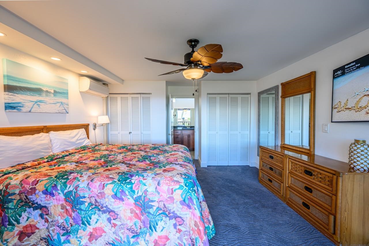 4909 Lower Honoapiilani Road, Unit D6 Lahaina, HI 96761 - Photo 25 of 47 a bedroom with a bed and a chandelier