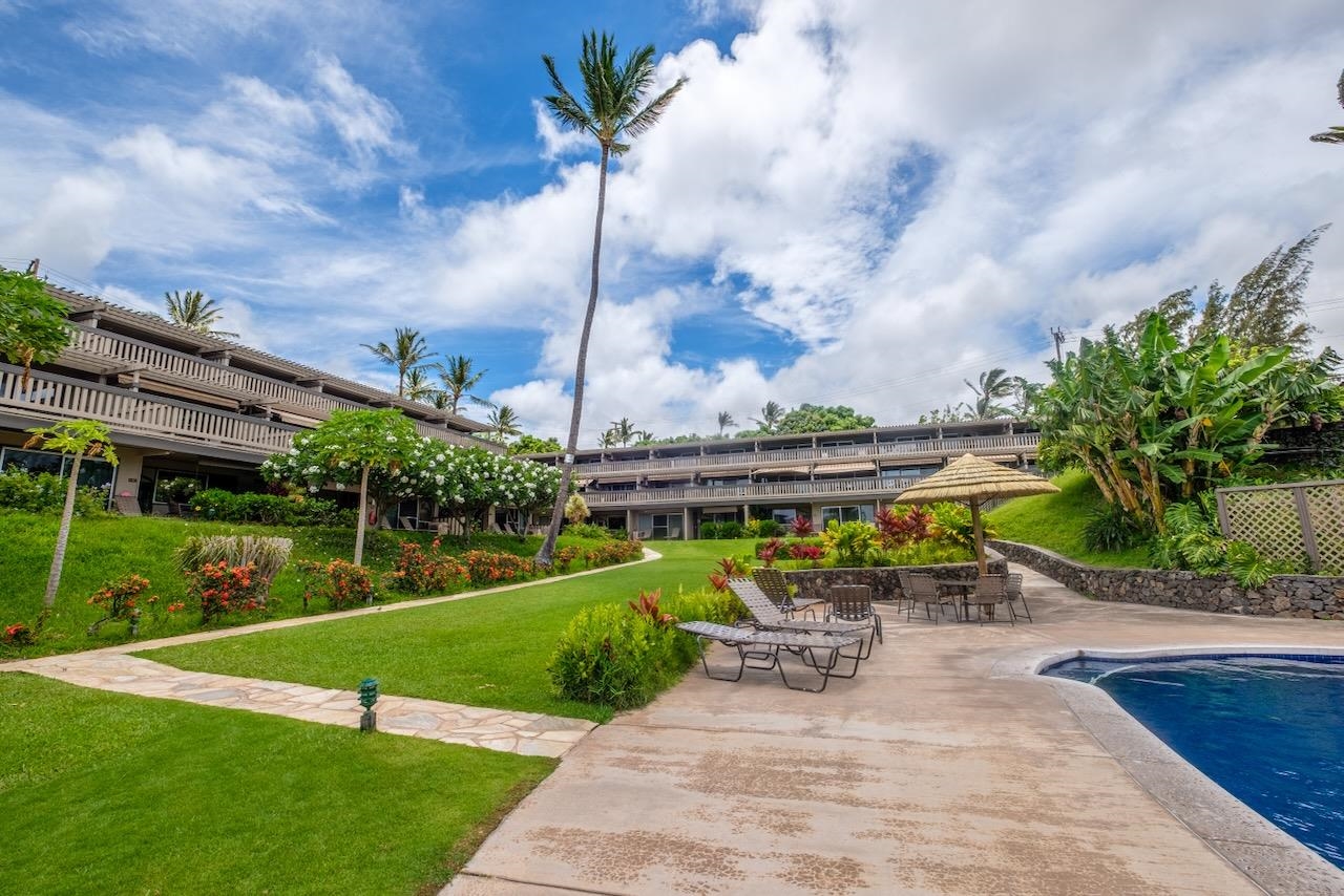 4909 Lower Honoapiilani Road, Unit D6 Lahaina, HI 96761 - Photo 30 of 47 a view of a patio with a table chairs and a yard