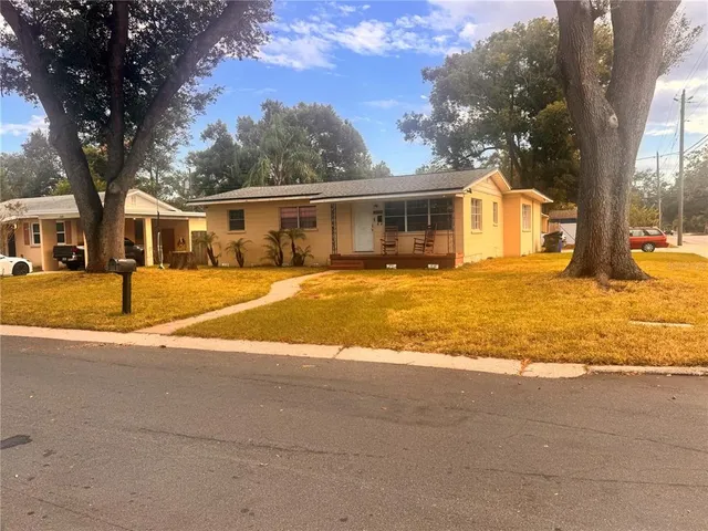 a front view of a house with a yard and trees