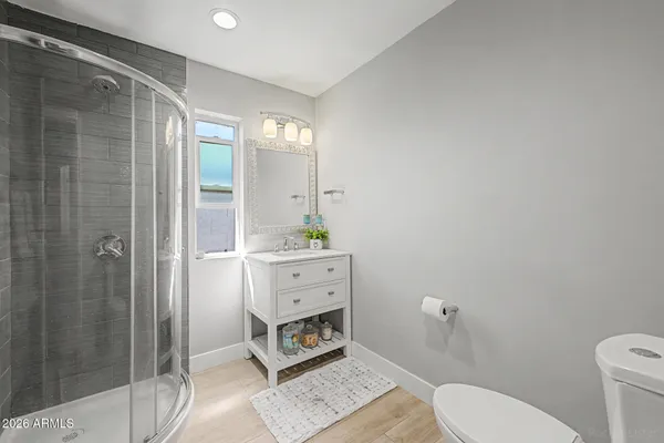 a bathroom with a granite countertop sink mirror and a toilet