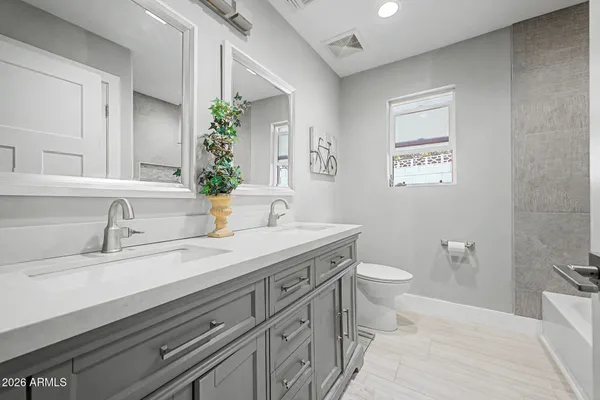 a spacious bathroom with a granite countertop sink and a bathtub