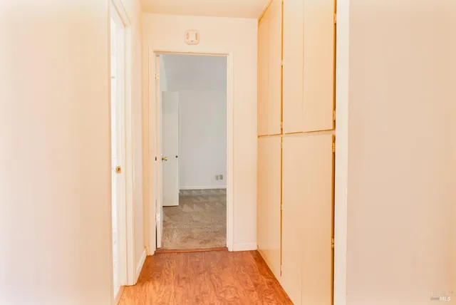 a view of a hallway with wooden floor