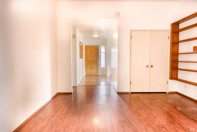 a view of a room with wooden floor and white doors