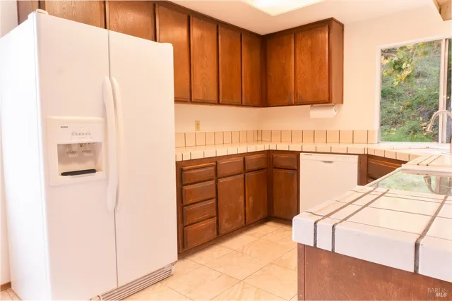 a kitchen with a refrigerator sink and cabinets