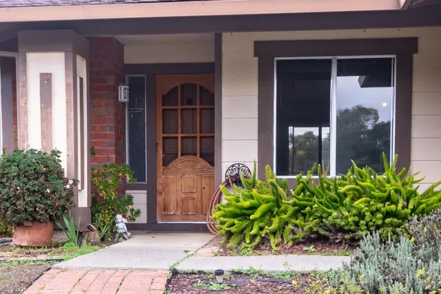 a front view of a house with a garden