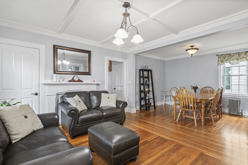 26 Maple Street Taunton, MA 02780 - Photo 15 of 31 a living room with furniture a dining table and a bookshelf with wooden floor
