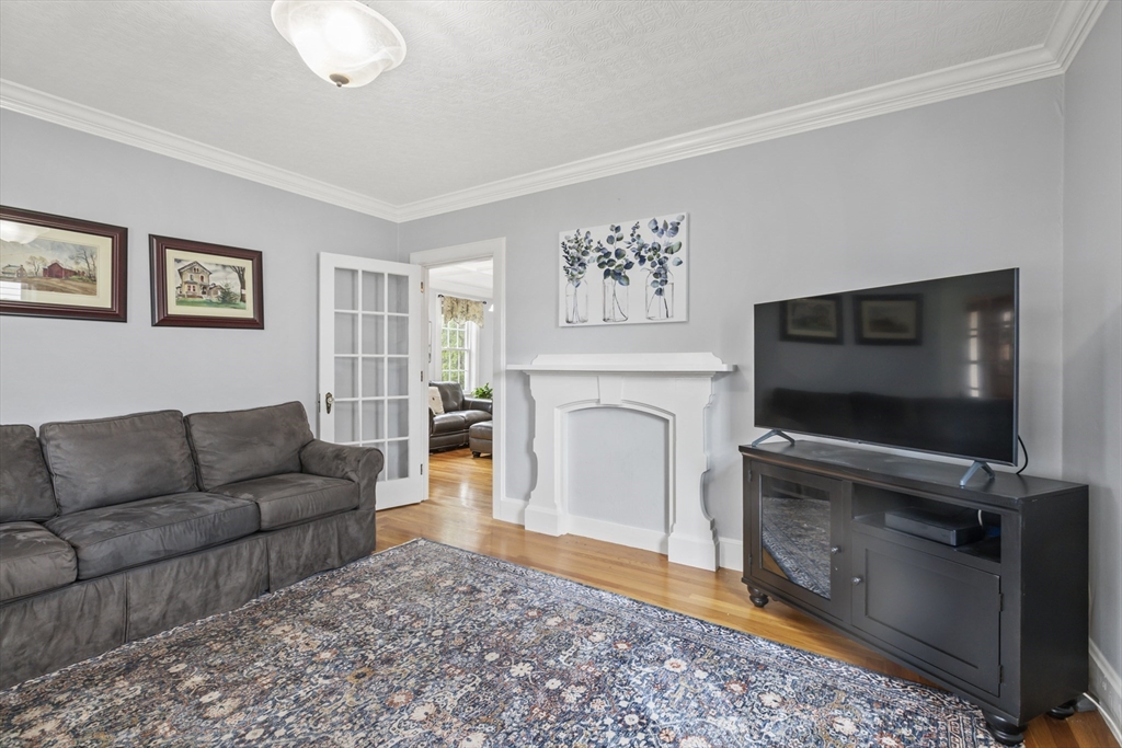 26 Maple Street Taunton, MA 02780 - Photo 19 of 31 a living room with furniture a flat screen tv and a fireplace
