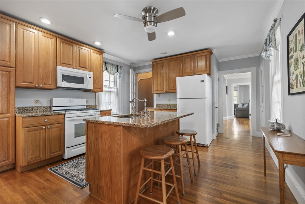 26 Maple Street Taunton, MA 02780 - Photo 9 of 31 a kitchen with stainless steel appliances granite countertop a refrigerator a stove top oven a sink dishwasher and white cabinets with wooden floor