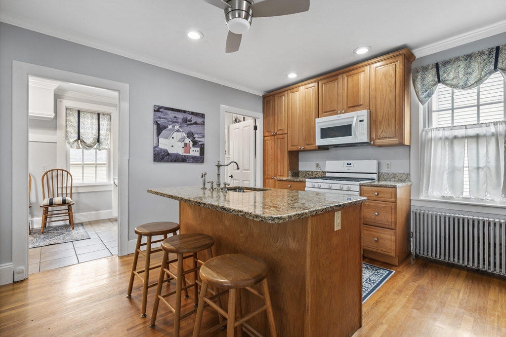 26 Maple Street Taunton, MA 02780 - Photo 10 of 31 a kitchen with stainless steel appliances granite countertop a stove top oven a sink a dining table and chairs with wooden floor