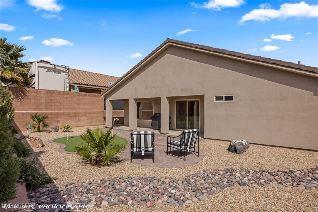 942 Shadow Hawk Ridge Mesquite, NV 89027 - Photo 52 of 67 Rear view of house with a putting green, a patio, and stucco siding