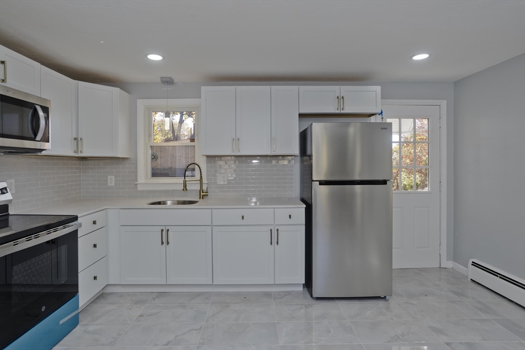 37 Wilber Street Springfield, MA 01104 - Photo 5 of 27 a kitchen with a refrigerator sink and cabinets
