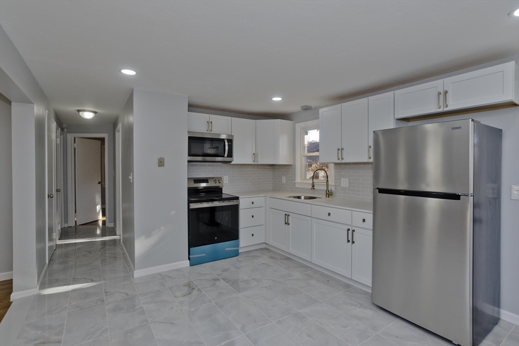 37 Wilber Street Springfield, MA 01104 - Photo 6 of 27 a kitchen with stainless steel appliances a refrigerator sink and microwave