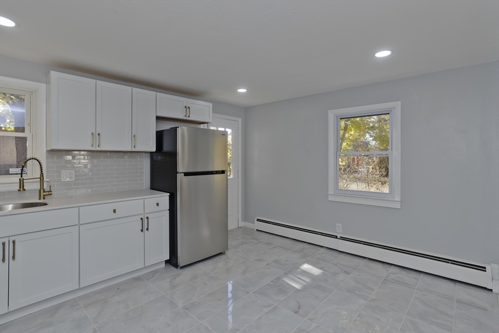 37 Wilber Street Springfield, MA 01104 - Photo 7 of 27 a kitchen with white cabinets and refrigerator