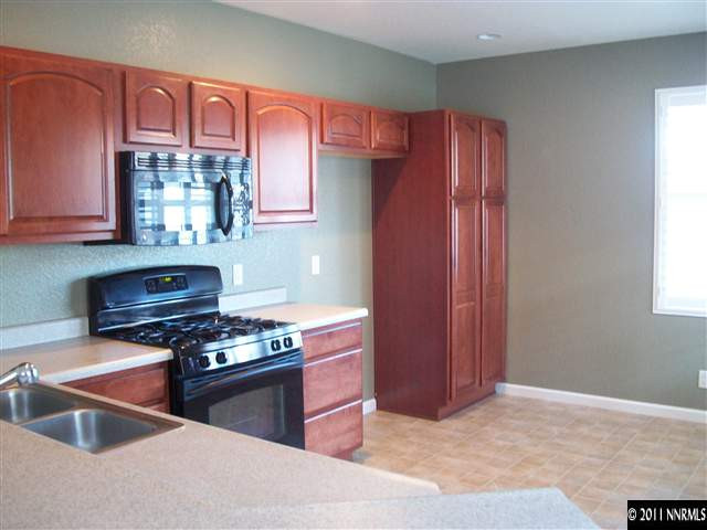 10055 Stonefield Drive Reno, NV 89521 - Photo 2 of 7 a kitchen with stainless steel appliances granite countertop a stove and a refrigerator