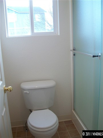 10055 Stonefield Drive Reno, NV 89521 - Photo 7 of 7 a white toilet sitting in a bathroom next to a window