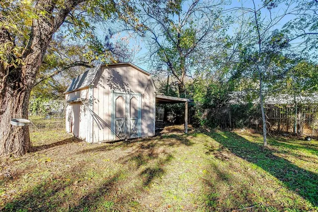 a white house that has tree in front of it