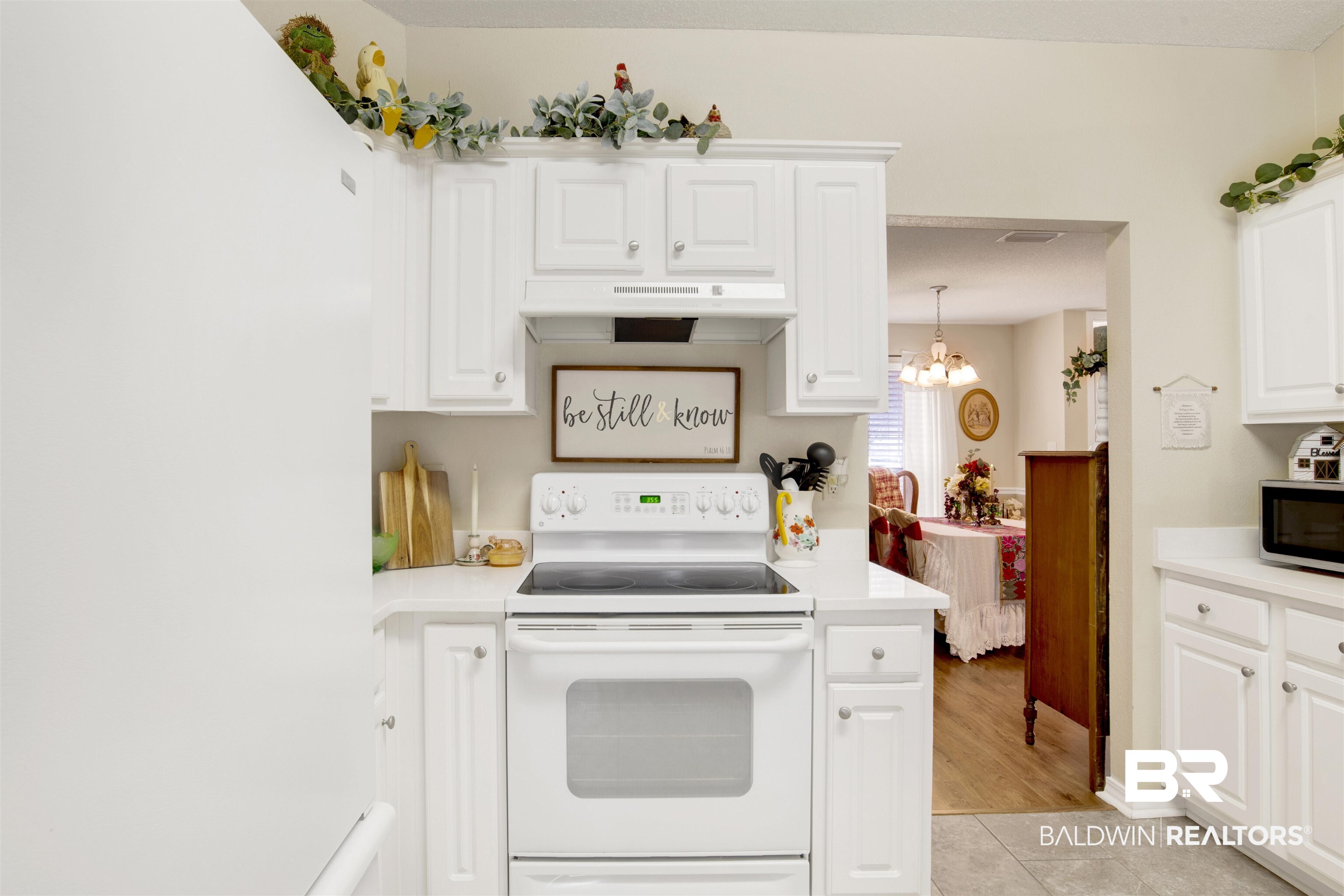 11697 Balsam Court Daphne, AL 36527 - Photo 15 of 31 Kitchen featuring light tile patterned floors, white appliances, white cabinetry, hanging light fixtures, and a chandelier
