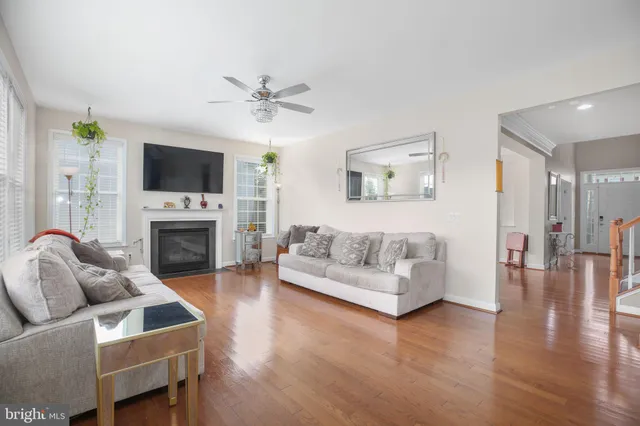 a kitchen with a stove a sink dishwasher and white cabinets with wooden floor