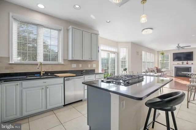 a kitchen with stainless steel appliances kitchen island granite countertop a refrigerator and cabinets