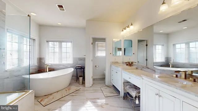 a white bath tub sitting in a bathroom next to a window