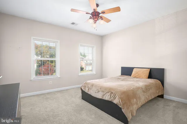 a bedroom with a bed chandelier and a window