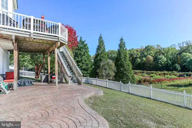 a view of a park with large trees and wooden fence