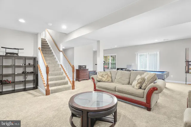 a living room with furniture a rug and white walls