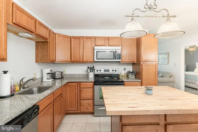 a kitchen with stainless steel appliances granite countertop a sink a stove and cabinets