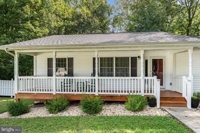 a view of a house with a small yard and wooden fence