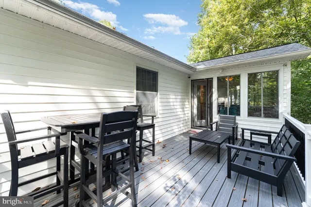 a view of a patio with table and chairs with wooden floor and fence
