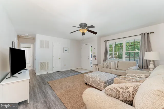 a living room with furniture a flat screen tv and a large window